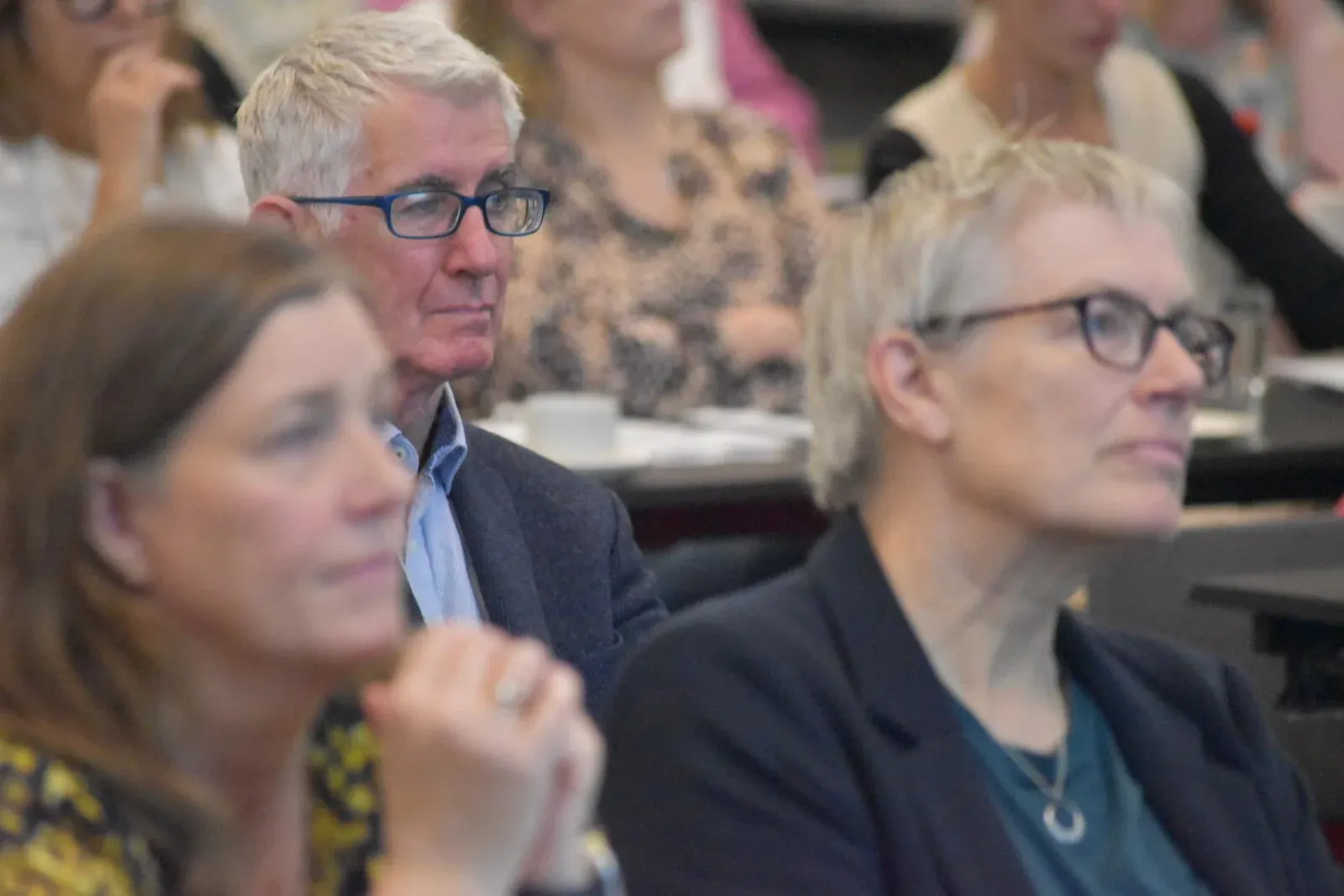 Two delegates listening to a presentation at the Annual Scientific Meeting